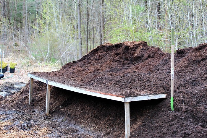 wooden table on top of big pile of potting mix