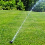 inground sprinkler watering lawn